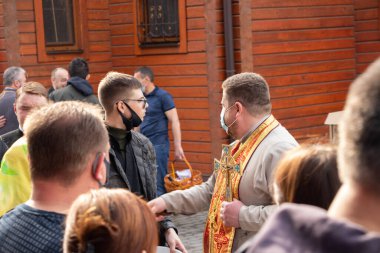 Ukrayna Dnipro, Dnipropetrovsk 02.05.2021 - Rahip Paskalya sepetlerini yiyecekle kutsadı. Tapınaktaki Hristiyanlar. Paskalyayı Ukrayna ve Paskalya 'da kutlama gelenekleri