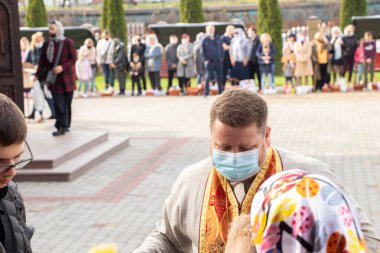 Ukrayna Dnipro, Dnipropetrovsk 02.05.2021 - Rahip Paskalya sepetlerini yiyecekle kutsadı. Tapınaktaki Hristiyanlar. Paskalyayı Ukrayna ve Paskalya 'da kutlama gelenekleri