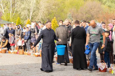 Ukrayna Dnipro, Dnipropetrovsk 02.05.2021 - Rahip Paskalya sepetlerini yiyecekle kutsadı. Tapınaktaki Hristiyanlar. Paskalyayı Ukrayna ve Paskalya 'da kutlama gelenekleri