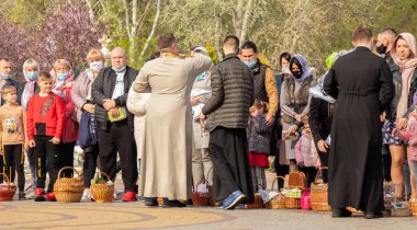 Ukrayna Dnipro, Dnipropetrovsk 02.05.2021 - Rahip Paskalya sepetlerini yiyecekle kutsadı. Tapınaktaki Hristiyanlar. Paskalyayı Ukrayna ve Paskalya 'da kutlama gelenekleri