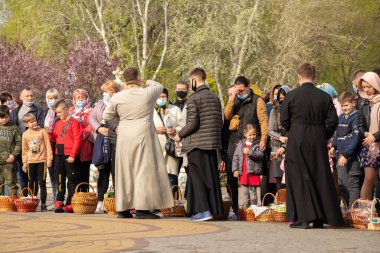 Ukrayna Dnipro, Dnipropetrovsk 02.05.2021 - Rahip Paskalya sepetlerini yiyecekle kutsadı. Tapınaktaki Hristiyanlar. Paskalyayı Ukrayna ve Paskalya 'da kutlama gelenekleri