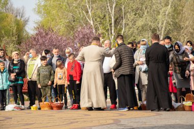 Ukrayna Dnipro, Dnipropetrovsk 02.05.2021 - Rahip Paskalya sepetlerini yiyecekle kutsadı. Tapınaktaki Hristiyanlar. Paskalyayı Ukrayna ve Paskalya 'da kutlama gelenekleri