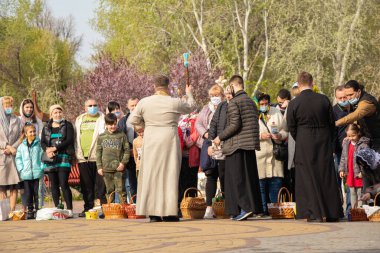 Ukrayna Dnipro, Dnipropetrovsk 02.05.2021 - Rahip Paskalya sepetlerini yiyecekle kutsadı. Tapınaktaki Hristiyanlar. Paskalyayı Ukrayna ve Paskalya 'da kutlama gelenekleri