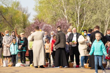 Ukrayna Dnipro, Dnipropetrovsk 02.05.2021 - Rahip Paskalya sepetlerini yiyecekle kutsadı. Tapınaktaki Hristiyanlar. Paskalyayı Ukrayna ve Paskalya 'da kutlama gelenekleri