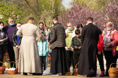 Ukrayna Dnipro, Dnipropetrovsk 02.05.2021 - Rahip Paskalya sepetlerini yiyecekle kutsadı. Tapınaktaki Hristiyanlar. Paskalyayı Ukrayna ve Paskalya 'da kutlama gelenekleri