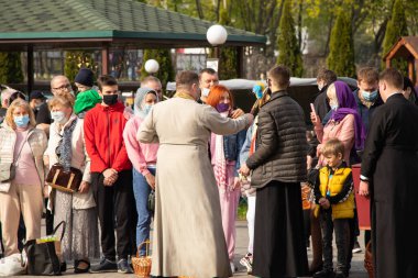 Ukrayna Dnipro, Dnipropetrovsk 02.05.2021 - Rahip Paskalya sepetlerini yiyecekle kutsadı. Tapınaktaki Hristiyanlar. Paskalyayı Ukrayna ve Paskalya 'da kutlama gelenekleri