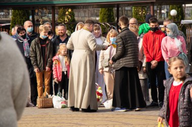 Ukrayna Dnipro, Dnipropetrovsk 02.05.2021 - Rahip Paskalya sepetlerini yiyecekle kutsadı. Tapınaktaki Hristiyanlar. Paskalyayı Ukrayna ve Paskalya 'da kutlama gelenekleri