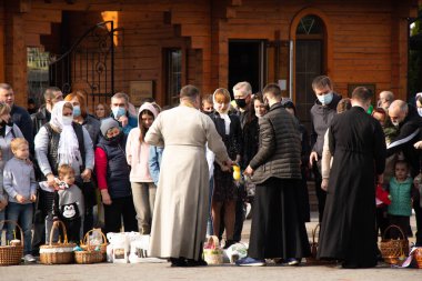 Ukrayna Dnipro, Dnipropetrovsk 02.05.2021 - Rahip Paskalya sepetlerini yiyecekle kutsadı. Tapınaktaki Hristiyanlar. Paskalyayı Ukrayna ve Paskalya 'da kutlama gelenekleri