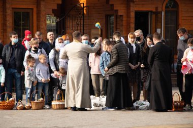 Ukrayna Dnipro, Dnipropetrovsk 02.05.2021 - Rahip Paskalya sepetlerini yiyecekle kutsadı. Tapınaktaki Hristiyanlar. Paskalyayı Ukrayna ve Paskalya 'da kutlama gelenekleri
