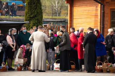 Ukrayna Dnipro, Dnipropetrovsk 02.05.2021 - Rahip Paskalya sepetlerini yiyecekle kutsadı. Tapınaktaki Hristiyanlar. Paskalyayı Ukrayna ve Paskalya 'da kutlama gelenekleri