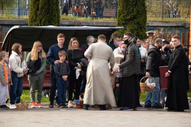 Ukrayna Dnipro, Dnipropetrovsk 02.05.2021 - Rahip Paskalya sepetlerini yiyecekle kutsadı. Tapınaktaki Hristiyanlar. Paskalyayı Ukrayna ve Paskalya 'da kutlama gelenekleri