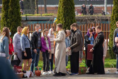 Ukrayna Dnipro, Dnipropetrovsk 02.05.2021 - Rahip Paskalya sepetlerini yiyecekle kutsadı. Tapınaktaki Hristiyanlar. Paskalyayı Ukrayna ve Paskalya 'da kutlama gelenekleri
