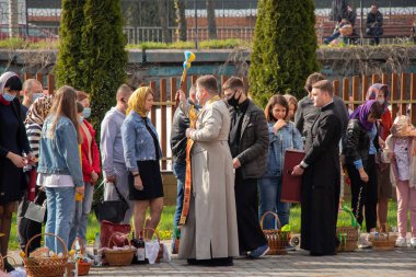 Ukrayna Dnipro, Dnipropetrovsk 02.05.2021 - Rahip Paskalya sepetlerini yiyecekle kutsadı. Tapınaktaki Hristiyanlar. Paskalyayı Ukrayna ve Paskalya 'da kutlama gelenekleri