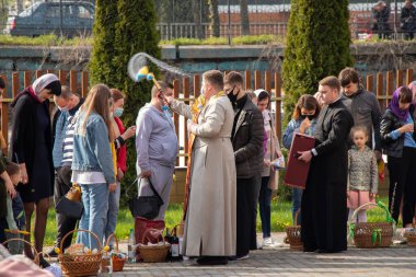 Ukrayna Dnipro, Dnipropetrovsk 02.05.2021 - Rahip Paskalya sepetlerini yiyecekle kutsadı. Tapınaktaki Hristiyanlar. Paskalyayı Ukrayna ve Paskalya 'da kutlama gelenekleri