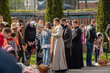 Ukrayna Dnipro, Dnipropetrovsk 02.05.2021 - Rahip Paskalya sepetlerini yiyecekle kutsadı. Tapınaktaki Hristiyanlar. Paskalyayı Ukrayna ve Paskalya 'da kutlama gelenekleri