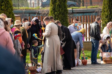 Ukrayna Dnipro, Dnipropetrovsk 02.05.2021 - Rahip Paskalya sepetlerini yiyecekle kutsadı. Tapınaktaki Hristiyanlar. Paskalyayı Ukrayna ve Paskalya 'da kutlama gelenekleri