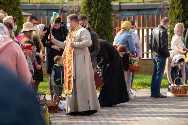 Ukrayna Dnipro, Dnipropetrovsk 02.05.2021 - Rahip Paskalya sepetlerini yiyecekle kutsadı. Tapınaktaki Hristiyanlar. Paskalyayı Ukrayna ve Paskalya 'da kutlama gelenekleri