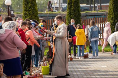 Ukrayna Dnipro, Dnipropetrovsk 02.05.2021 - Rahip Paskalya sepetlerini yiyecekle kutsadı. Tapınaktaki Hristiyanlar. Paskalyayı Ukrayna ve Paskalya 'da kutlama gelenekleri