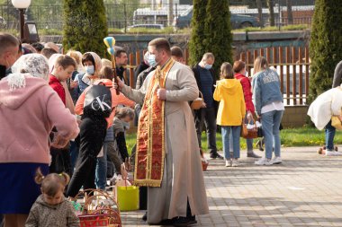 Ukrayna Dnipro, Dnipropetrovsk 02.05.2021 - Rahip Paskalya sepetlerini yiyecekle kutsadı. Tapınaktaki Hristiyanlar. Paskalyayı Ukrayna ve Paskalya 'da kutlama gelenekleri