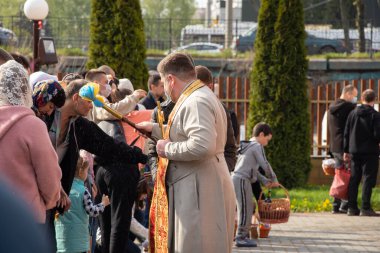 Ukrayna Dnipro, Dnipropetrovsk 02.05.2021 - Rahip Paskalya sepetlerini yiyecekle kutsadı. Tapınaktaki Hristiyanlar. Paskalyayı Ukrayna ve Paskalya 'da kutlama gelenekleri