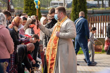 Ukrayna Dnipro, Dnipropetrovsk 02.05.2021 - Rahip Paskalya sepetlerini yiyecekle kutsadı. Tapınaktaki Hristiyanlar. Paskalyayı Ukrayna ve Paskalya 'da kutlama gelenekleri