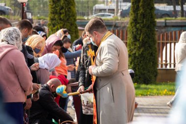 Ukrayna Dnipro, Dnipropetrovsk 02.05.2021 - Rahip Paskalya sepetlerini yiyecekle kutsadı. Tapınaktaki Hristiyanlar. Paskalyayı Ukrayna ve Paskalya 'da kutlama gelenekleri