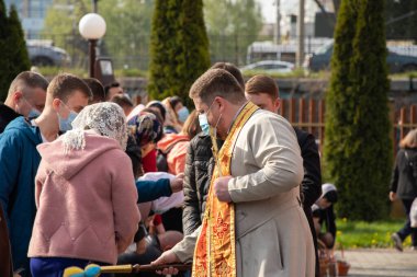 Ukrayna Dnipro, Dnipropetrovsk 02.05.2021 - Rahip Paskalya sepetlerini yiyecekle kutsadı. Tapınaktaki Hristiyanlar. Paskalyayı Ukrayna ve Paskalya 'da kutlama gelenekleri