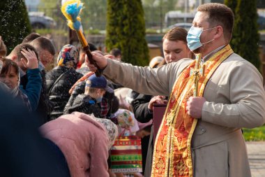 Ukrayna Dnipro, Dnipropetrovsk 02.05.2021 - Rahip Paskalya sepetlerini yiyecekle kutsadı. Tapınaktaki Hristiyanlar. Paskalyayı Ukrayna ve Paskalya 'da kutlama gelenekleri