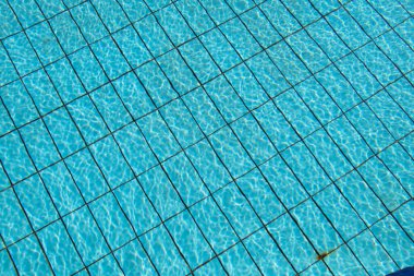 Arka plan kapanırken mavi tabanlı havuz güneşin altında hareket ediyor