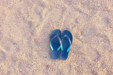 Plaj lastik ayakkabıları kumun üzerinde.