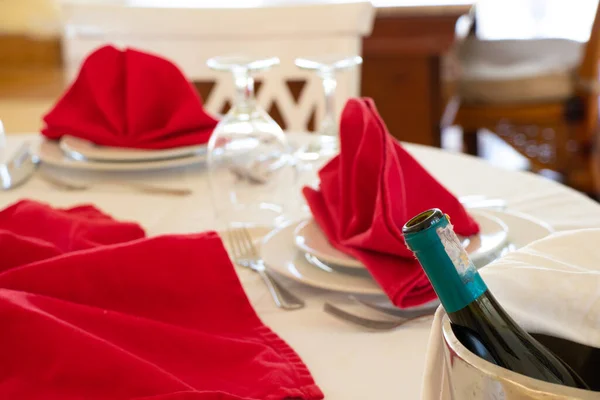 Catering services. Glasses without wine and plates with a red napkin on a white tablecloth, table for a party or wedding reception, table setting for a celebration
