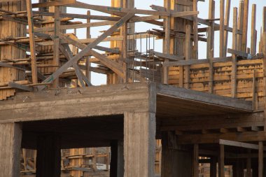 Mavi gökyüzünün arka planında çölde yeni bir otel inşaatı, bir bina inşaatı.