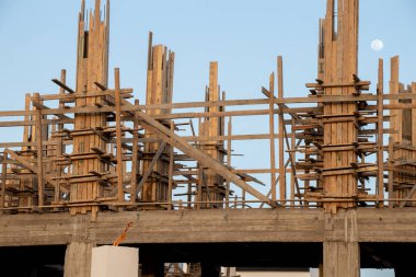 Mavi gökyüzünün arka planında çölde yeni bir otel inşaatı, bir bina inşaatı.