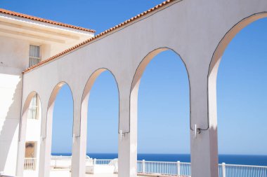 Mısır 'daki Kızıl Deniz kıyısındaki verandaya erişimi olan kemerli bir geçit. Mavi gökyüzünün arka planında kemerli bir bina.