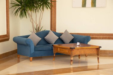 Mısırda bir otelin oturma odasındaki salonda mavi yumuşak bir kanepe ve bir sehpa güneşte camları yerleştirdi..