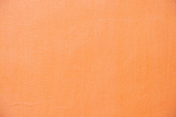 light orange painted wall outdoors as background close-up, pink background