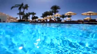 Güneşli bir sabahta havuzdan Mısırlı otellere kadar çekim yapmak, havuzda yüzmek, havuzun manzarası.
