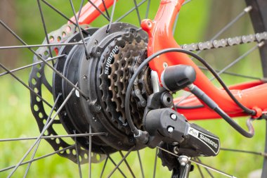 Ukrayna Dnipro 08.05 .2021 - doğadaki bir parkta duran yeni kırmızı elektrikli bisiklet, yeni teknolojiler