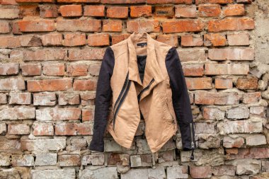 Esmer kadın ceketi asılıydı evdeki eski tuğla duvarda asılı, kadın modası.