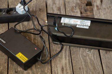 Ukrayna Dnipro - 13.05.2021 - elektrikli motorlu bir elektro pil ahşap zemin ve elektro taşıma ile şarj edilir.