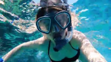 Maskeli ve şnorkeli olan bir kız Mısır 'da kızıl denizde yüzer, şnorkelle yüzer.