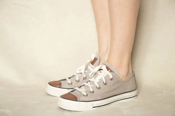 Vrouwelijke Benen Textiel Bruine Sneakers Een Witte Achtergrond Close — Stockfoto