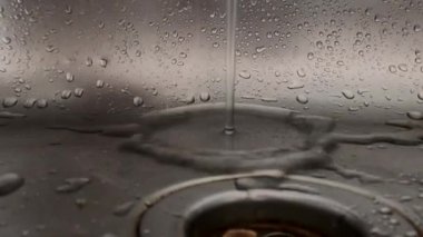 water flows from the tap in the kitchen sink, close-up of the kitchen sink