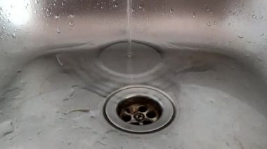 water flows from the tap in the kitchen sink, close-up of the kitchen sink