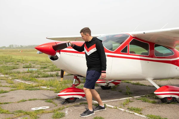 ウクライナのドニプロ市の飛行場の小さな飛行機の近くに若い男が立っています — ストック写真