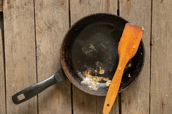 Yemekten sonra eski kirli tava ahşap bir masada duruyor yakın plan mutfak gereçleri