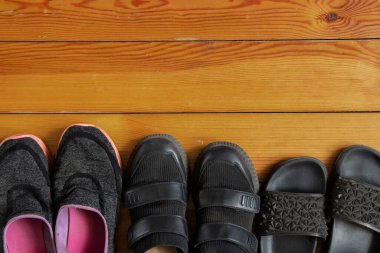 sneakers flip flops sneakers are in a row on a wooden floor different, a lot of women's shoes on the floor