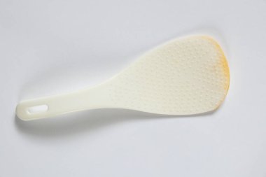 Beyaz plastik kaşık, izole ışık arka planında yatıyor. Yakın plan, kaşık.