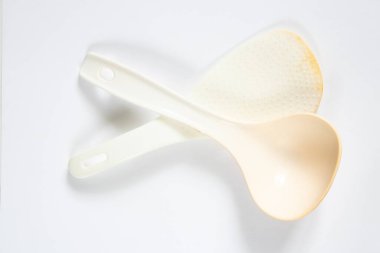 Beyaz plastik kaşık, izole ışık arka planında yatıyor. Yakın plan, kaşık.