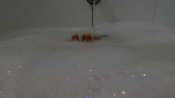 Női lábak egy szappanos vízben, egy lány a fürdőszobában mosakszik. — Stock videók